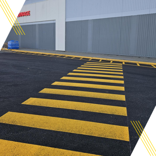 Passage piéton jaune fraîchement peint devant un bâtiment commercial
